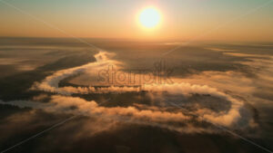 Premium stock cinematic video footage – Aerial drone view of fog over a windy Nistru river at sunrise with red sky in Moldova - Starpik Stock
