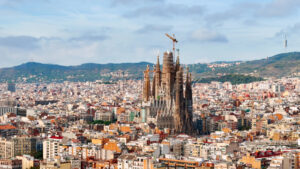 Aerial drone view of Sagrada Familia in city downtown. Famous residential districts around, greenery - Starpik