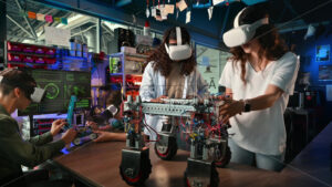 Group of young people in VR glasses doing experiments in robotics in a laboratory. Robots on the table - Starpik