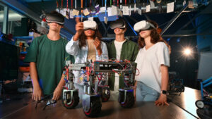 Premium stock video footage – Group of young people discussing and putting on VR glasses while doing experiments in robotics in a laboratory. Robot on the table - Starpik Stock