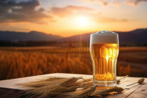 A glass of beer on a table with a wheat field in the background - Starpik