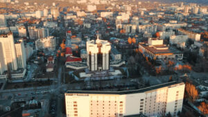 Aerial drone view of Chisinau at sunset. Panorama view of the Presidency and Parliament, multiple buildings in city center, roads with moving cars, bare trees. Moldova - Starpik Stock