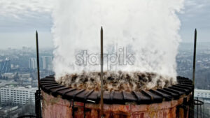 Aerial drone view of Chisinau. Tube of the thermal station with smoke coming out. Cityscape on the background. Cloudy weather. Moldova - Starpik Stock