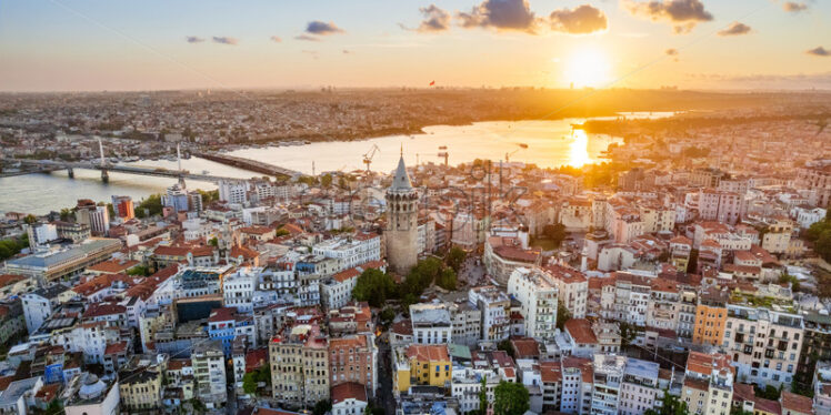 Aerial drone view of Istanbul at sunset, Turkey. Multiple residential buildings around the Galata tower, Golden Horn waterway on the background - Starpik Stock