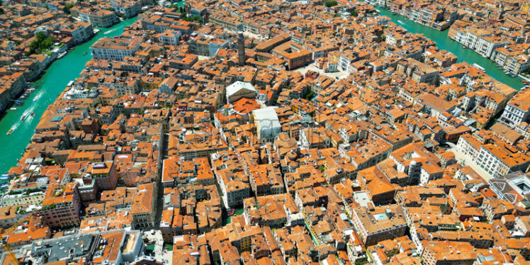 Aerial drone view of Venice, Italy. Water channels, historical city centre with old residential buildings and narrow streets - Starpik Stock