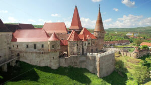 Aerial drone view of the Corvin Castle located in Hunedoara, Romania. People inside. Greenery and buildings around - Starpik Stock