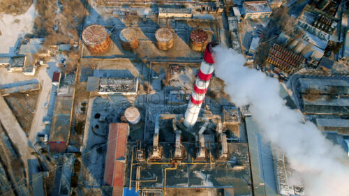 Aerial drone view of thermoelectric tower with white smoke in winter - Starpik Stock