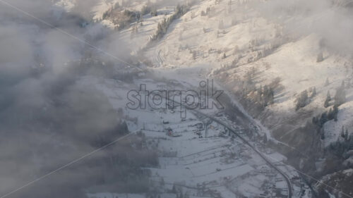 Aerial drone view of winter mountains with fog in Ceahlau National Park, Romania - Starpik Stock