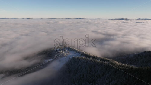 Aerial drone view of winter mountains with fog in Ceahlau National Park, Romania - Starpik Stock