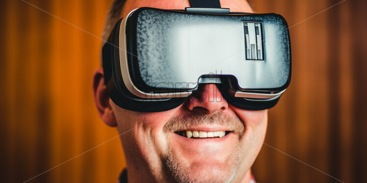 American man enjoying what he sees in his virtual reality goggles in their living room  - Starpik Stock