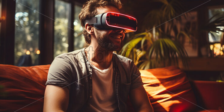 American man happily wearing his virtual reality goggles in their entertainment room with reflection on his goggles  - Starpik Stock