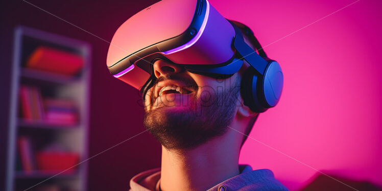 American man happily wearing his virtual reality goggles in their modern entertainment room with pink lights - Starpik Stock