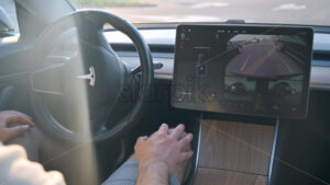 CHISINAU, MOLDOVA – MAY, 2023: Interior view of a Tesla Model 3 parking on autopilot. Driver not touching the steering wheel - Starpik Stock