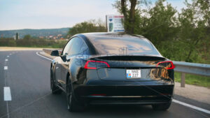 CHISINAU, MOLDOVA – MAY, 2023: Rear view of black Tesla Model 3 accelerating on a highway. Slow motion - Starpik Stock