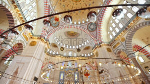 Interior view of the Suleymaniye mosque in Istanbul, Turkey. A lot of illumination, painted ceiling, red carpet - Starpik Stock