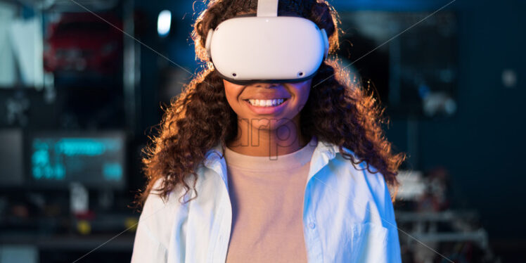 Portrait of a black young smiling girl in VR glasses - Starpik Stock