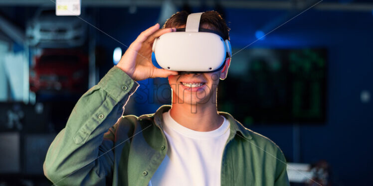 Portrait of a young smiling man in VR glasses - Starpik Stock