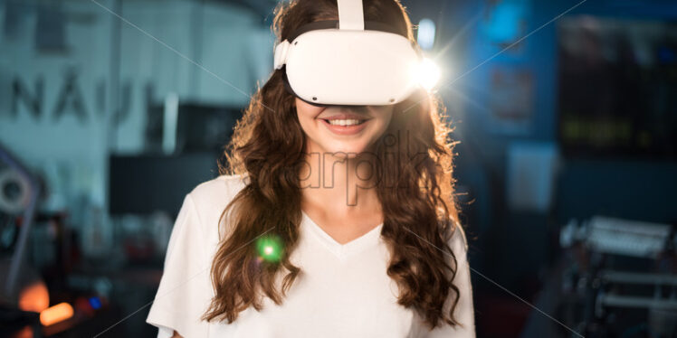 Portrait of a young smiling woman in VR glasses - Starpik Stock