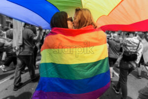 Pride parade in center of Chisinau, Moldova. A couple kissing with rainbow flag above - Starpik Stock