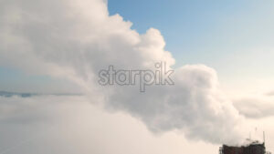 VIDEO – Aerial drone view of Chisinau. Tube of the thermal station with smoke coming out above the low clouds. Visible buildings. Moldova - Starpik