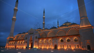View of the Camlica Mosque in Istanbul at evening, Turkey. Facade made of white stone, illumination, few people in front of it - Starpik Stock