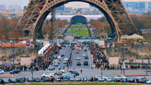 View of the cinematic Eiffel Tower in Paris from the Trocadero Square at sunset, France. Jena Bridge with multiple people and cars, Champ de Mars on the background - Starpik Stock