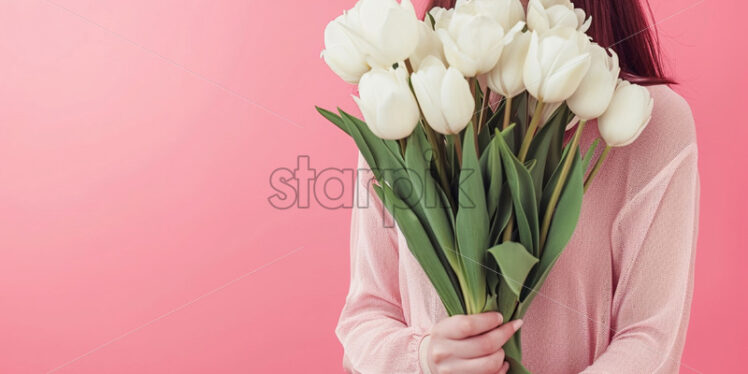 A girl holding a bouquet of tulips on a pink background - Starpik Stock