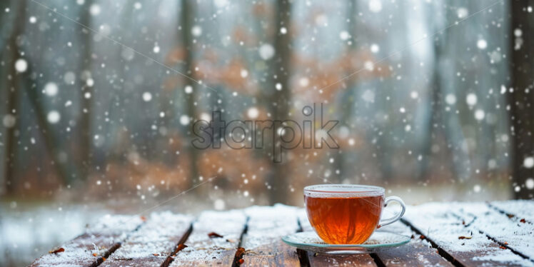 An aromatic cup of tea in winter on a table in the forest - Starpik Stock