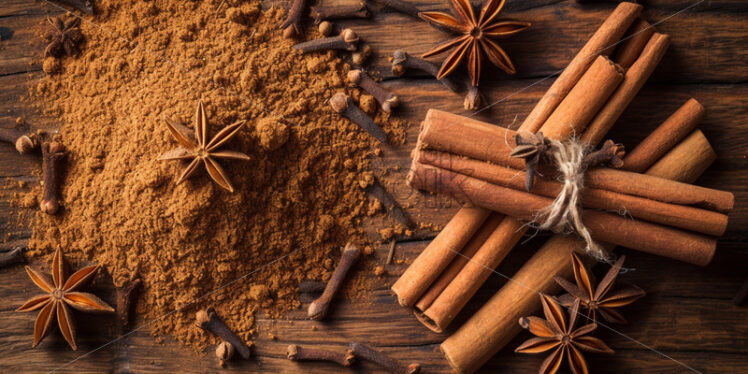 Ground cinnamon and whole cloves on a wood surface - Starpik Stock