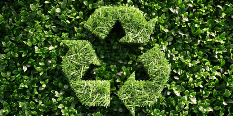 The recycling symbol created from grass on a green background - Starpik Stock