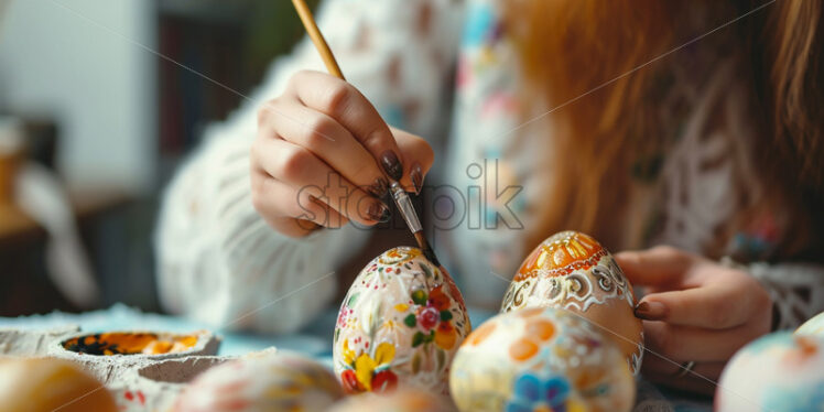 Woman painting traditional romanian easter eggs - Starpik Stock