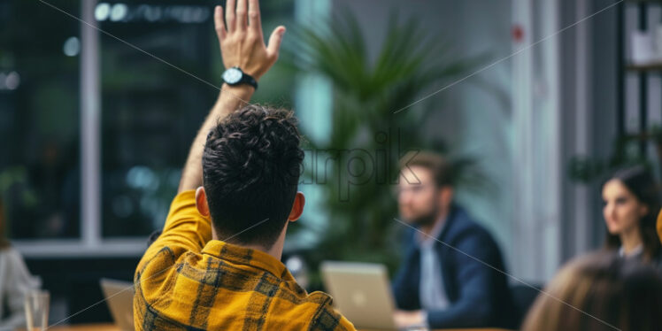 A man in the office with his hand raised - Starpik Stock