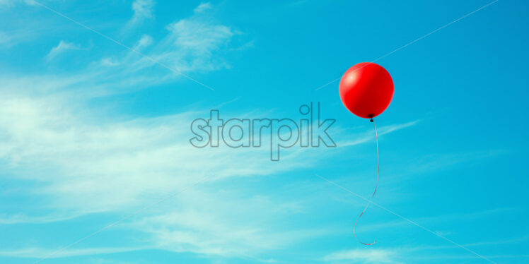 A red balloon flies in the sky - Starpik Stock