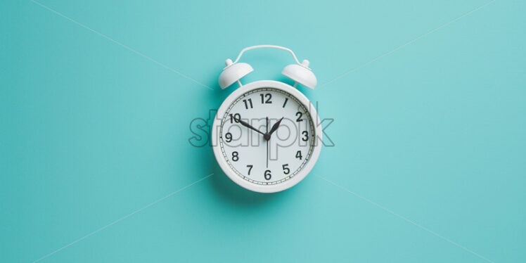 A white clock on a blue wall - Starpik Stock