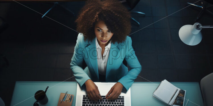 Woman in an office working at a lap top - Starpik Stock