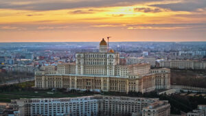 Aerial drone view of Palace of the Parliament in Bucharest downtown at sunset. Multiple districts around, Romania - Starpik Stock