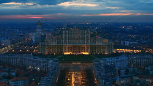 Aerial hyperlpase timelapse drone view of illuminated Palace of the Parliament in Bucharest downtown in the evening. Multiple districts around. Romania - Starpik