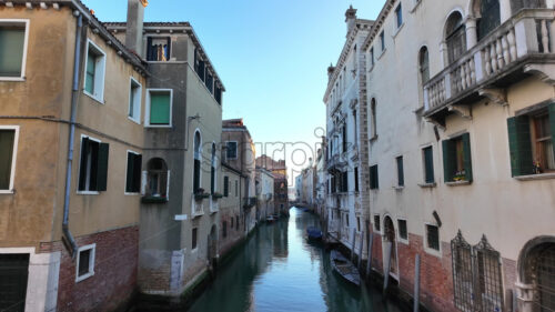 Boats docked on the side of a canal in Venice, Italy - Starpik Stock