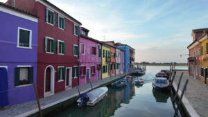 Boats on the sides of a canal near the colourful houses of Burano Island, Italy - Starpik Stock