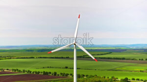 VIDEO Aerial drone view of a wind turbine in a field on a cloudy day - Starpik