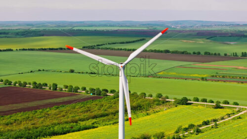 VIDEO Aerial drone view of a wind turbine in a field on a cloudy day - Starpik