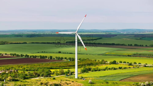 VIDEO Aerial drone view of a wind turbine in a field on a cloudy day - Starpik