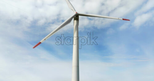 VIDEO Aerial drone view of a wind turbine in a field on a cloudy day - Starpik