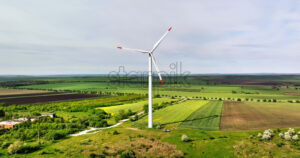 VIDEO Aerial drone view of a wind turbine in a field on a cloudy day - Starpik