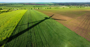 VIDEO Aerial drone view of a wind turbine shadow on an agricultural field - Starpik