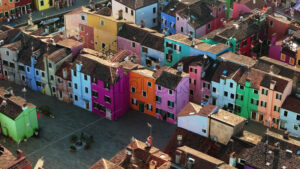 VIDEO Aerial drone view of boats on the sides of a canal near the colourful houses of Burano, Italy - Starpik