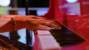 VIDEO Close-up of an elderly woman playing a red piano - Starpik