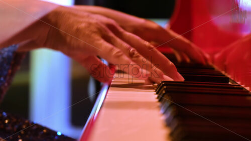 VIDEO Close-up of an elderly woman playing a red piano - Starpik