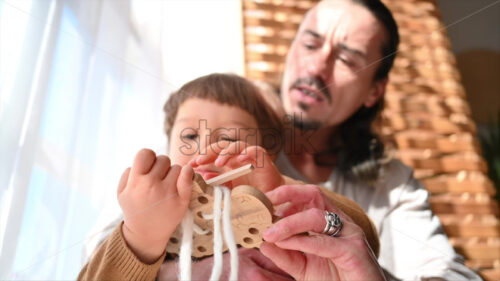 VIDEO Father playing with his son with ecological wooden toys near the window - Starpik