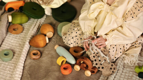 VIDEO Overhead view of two little girls playing with wooden toys on the bed. Ecological and sustainability concept - Starpik